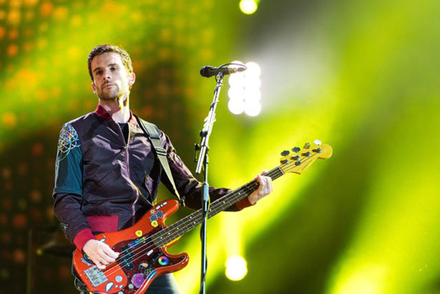 A photo of Guy Berryman playinh bass on the AHFOD tour